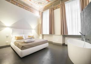 a bedroom with a bed and a bath tub in it at LUCUS Exclusive Bed and Breakfast in Lucca