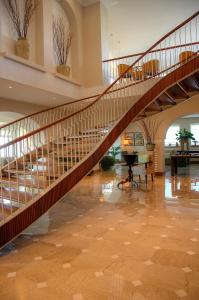 a spiral staircase in a lobby with a table and chairs at Grand Hotel Aminta in Sorrento