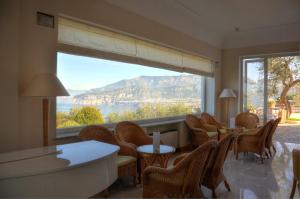 a room with a table and chairs and a large window at Grand Hotel Aminta in Sorrento