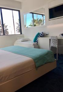 a hotel room with two beds and a desk at SoBlue Hôtel in Antibes