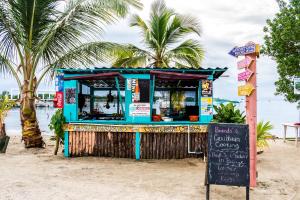 a food stand on the beach with a sign at Carol's Cabanas in Placencia Village