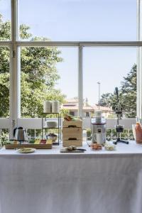 Hotel Beatrice في إستيه: منضدة بيضاء مع طعام عليها نوافذ