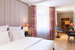 a hotel room with a bed and a desk at Hotel Perrin - former Carlton in Luxembourg