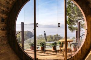 ein großes rundes Fenster in einem Zimmer mit einem Tisch und Stühlen in der Unterkunft Cella Grande in Viverone