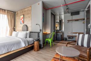 a bedroom with a bed and a table and a couch at MeStyle Museum Hotel in Bangkok +220 photos
