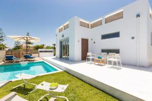 a villa with a swimming pool and a backyard at Thalasses in Adelianos Kampos