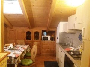 eine kleine Küche mit einem Tisch und eine Küche mit in der Unterkunft 9598 SS301 Trepalle APPARTAMENTO MIKI in Livigno