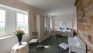 ラインスヴァイラーにあるHotel Leinsweiler Hofのベッドルーム1室(ベッド1台、テーブル、椅子付)