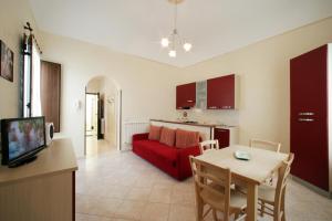 sala de estar con sofá rojo y mesa en La Dimora dell'800, en Trapani