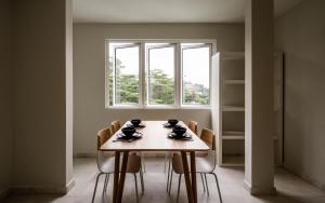 a dining room table with chairs and a window at Changkat Duta Luxury Villa (Event Space) in Kuala Lumpur