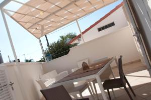 un patio con tavolo e sedie in legno su un balcone di Torre Lapillo Centro GMA Tourism a Torre Lapillo