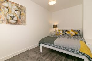 a bedroom with a bed with a painting on the wall at Denby Lodge in Letchworth
