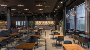 a restaurant with tables and chairs and windows at Break Sokos Hotel Flamingo in Vantaa