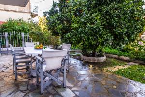 una mesa y sillas sentadas junto a un árbol en Regalo Apartments, en Ligia