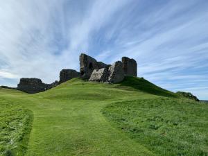 a castle on top of a grassy hill at Hayfield Apartment in Lossiemouth