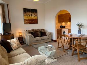 een woonkamer met een bank en een tafel bij Hayfield Apartment in Lossiemouth