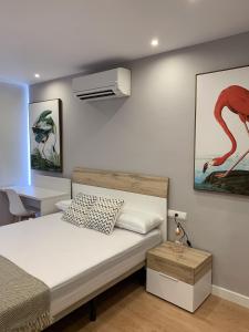 a bedroom with a bed and a picture of a bird at Be Free Ramos in Almería