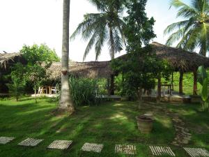 une maison avec un palmier et une cour dans l'établissement Coconut Island, à Tangalle