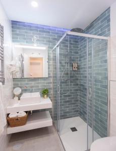 a bathroom with a glass shower and a sink at MIMA Suites Chueca in Madrid