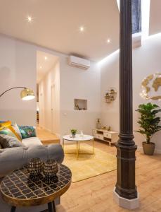 uma sala de estar com um sofá e uma mesa em MIMA Suites Chueca em Madrid