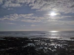 een uitzicht op de oceaan met de zon in de lucht bij Moon in Playa de las Americas