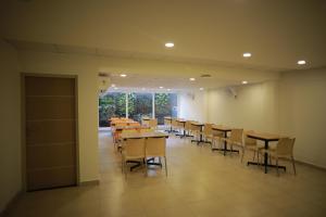 a dining room with tables and chairs in it at Zoot Kochi Infopark in Cochin