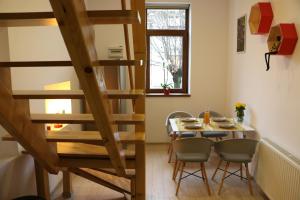 a dining room with a table and a wooden staircase at Fagaras Cosy Flat in Făgăraş