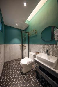 a bathroom with a toilet and a sink and a mirror at Reunion Carnarvon in George Town