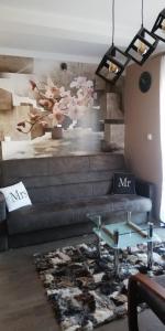 a living room with a couch and a flower mural at ComfortStudio in Zakopane