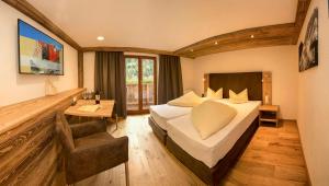 a hotel room with a bed and a desk at Hotel Edelweiss Superior in Kaunertal