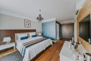 a bedroom with a large bed with a blue headboard at Eola Leisure Rooms in Stara Baška