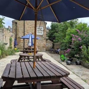 a picnic table with an umbrella on a patio at Coach and Horses in Barnard Castle