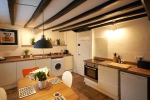 eine Küche mit einem Holztisch und eine Küche mit einem Waschbecken in der Unterkunft No 88 UPPER ST GILES - Elegant, Stylish Townhouse in Norwich