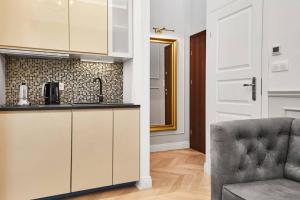 una cucina con bancone e sedia in una stanza di HOUSEHOST Apartment I: Studencka Street a Cracovia