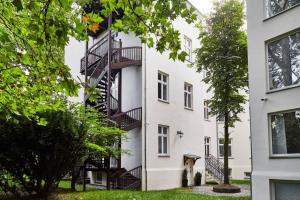 a white building with a spiral staircase on the side at HOUSEHOST Apartment I: Studencka Street in Kraków