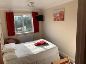 a bedroom with a bed with a red shirt on it at Weston Grounds Farm in Bicester