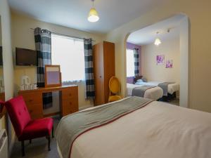 a hotel room with a bed and a chair at OYO Shanklin Beach Hotel in Shanklin