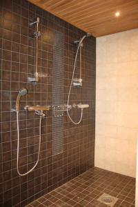 a shower in a bathroom with brown tiles at Villa Castillo in Saariselka