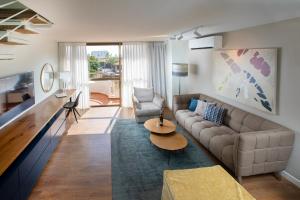 a living room with a couch and a table at Marine Heights Suites in Herzelia 