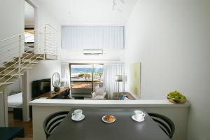 cocina y sala de estar con mesa de comedor en Marine Heights Suites en Herzelia 