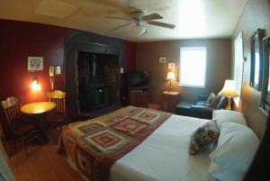 a living room with a fireplace and a bed at Sleepy Forest Cottages in Big Bear Lake