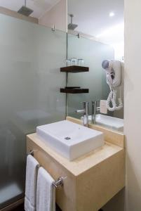 W łazience znajduje się biała umywalka i lustro. w obiekcie Park Royal City Buenos Aires w BuenosAires