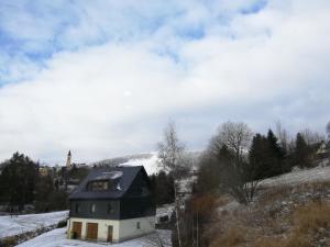 a house on a hill with snow on the ground at Ferienhaus Kaufmanns Cafe in Kurort Oberwiesenthal