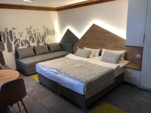 ein Schlafzimmer mit einem Bett und einer Couch in der Unterkunft Apartment 101 - Aparthotel Vucko Jahorina private host in Jahorina