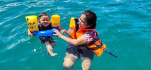 a woman and a child in the water at Kohmook Nurse House in Koh Mook