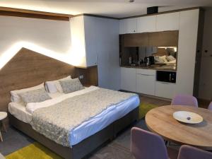 ein Schlafzimmer mit Bett und Tisch und eine Küche in der Unterkunft Apartment 101 - Aparthotel Vucko Jahorina private host in Jahorina