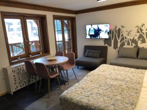a room with a table and a couch and a tv at Apartment Vucko 101 in Jahorina