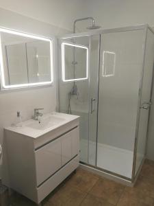 a white bathroom with a shower and a sink at Casa do Imaculado in Funchal