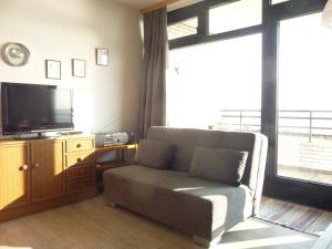 a living room with a couch and a television at STHS79125-FeWo-Oostseebreker in Staberdorf +4 photos