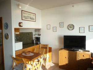 a living room with a television and a table with a dining room at STHS79125-FeWo-Oostseebreker in Staberdorf